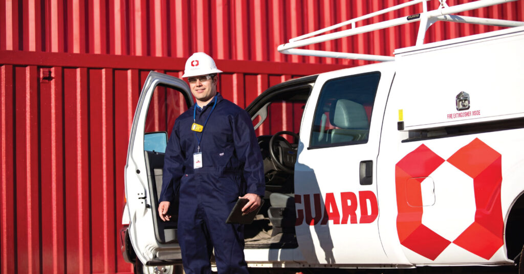 RedGuard field service technician standing beside a RedGuard service truck at an industrial site.